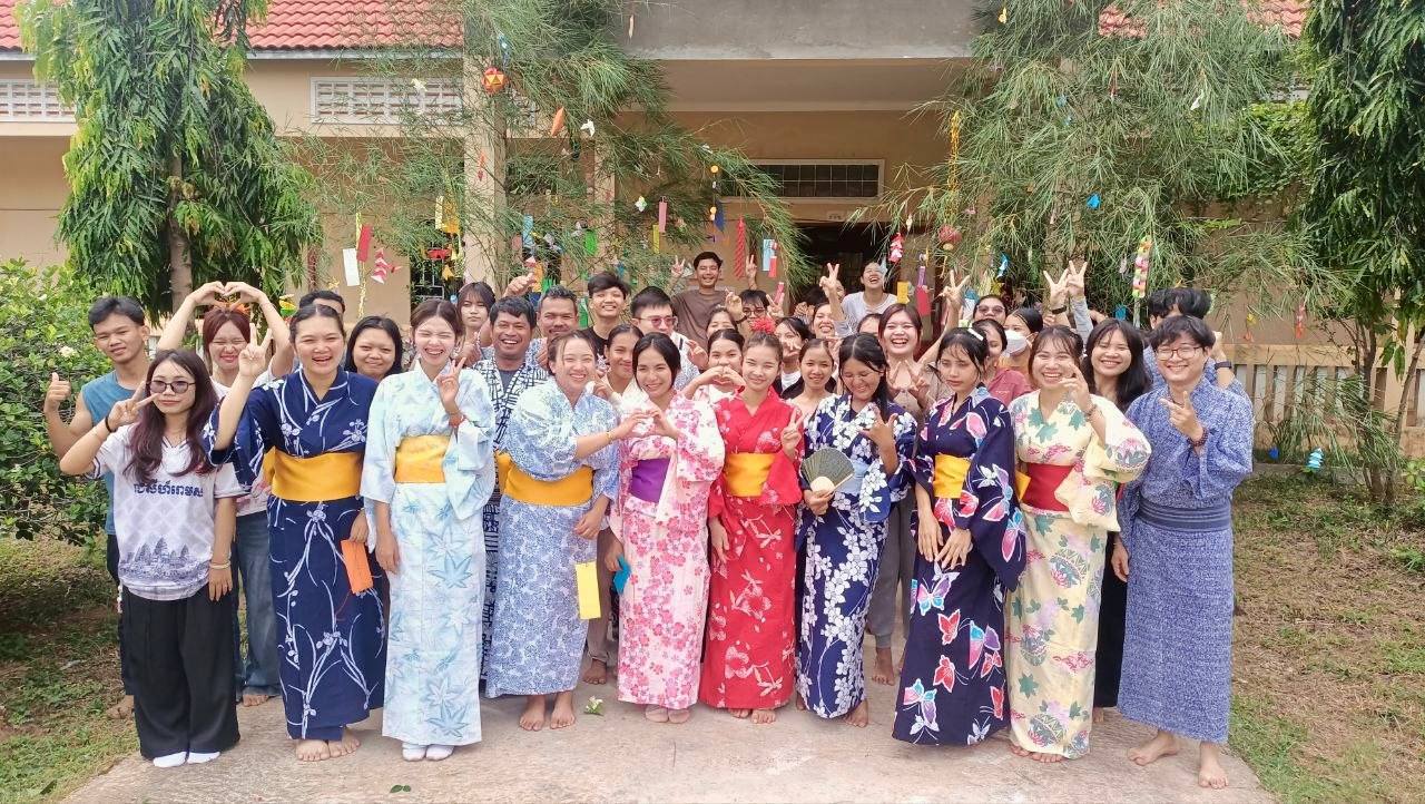 笹に七夕飾りを並べる山本日本語学校の生徒たち